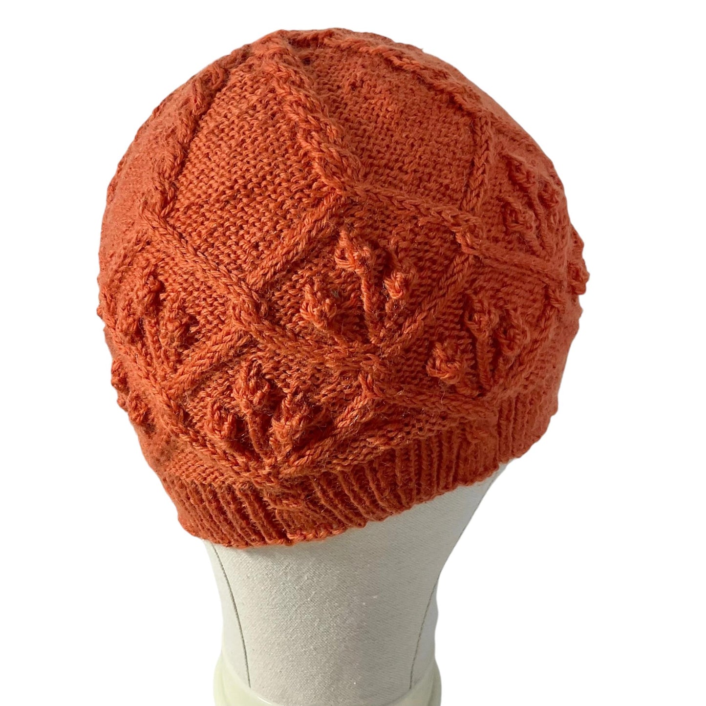 hand knitted cable and bobble hat in burnt orange