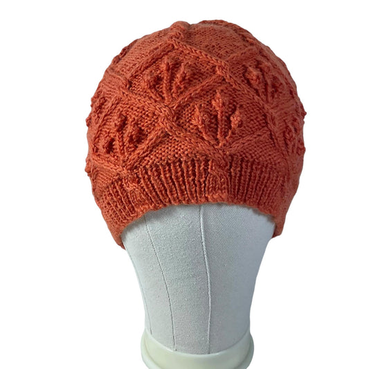 hand knitted cable and bobble hat in burnt orange