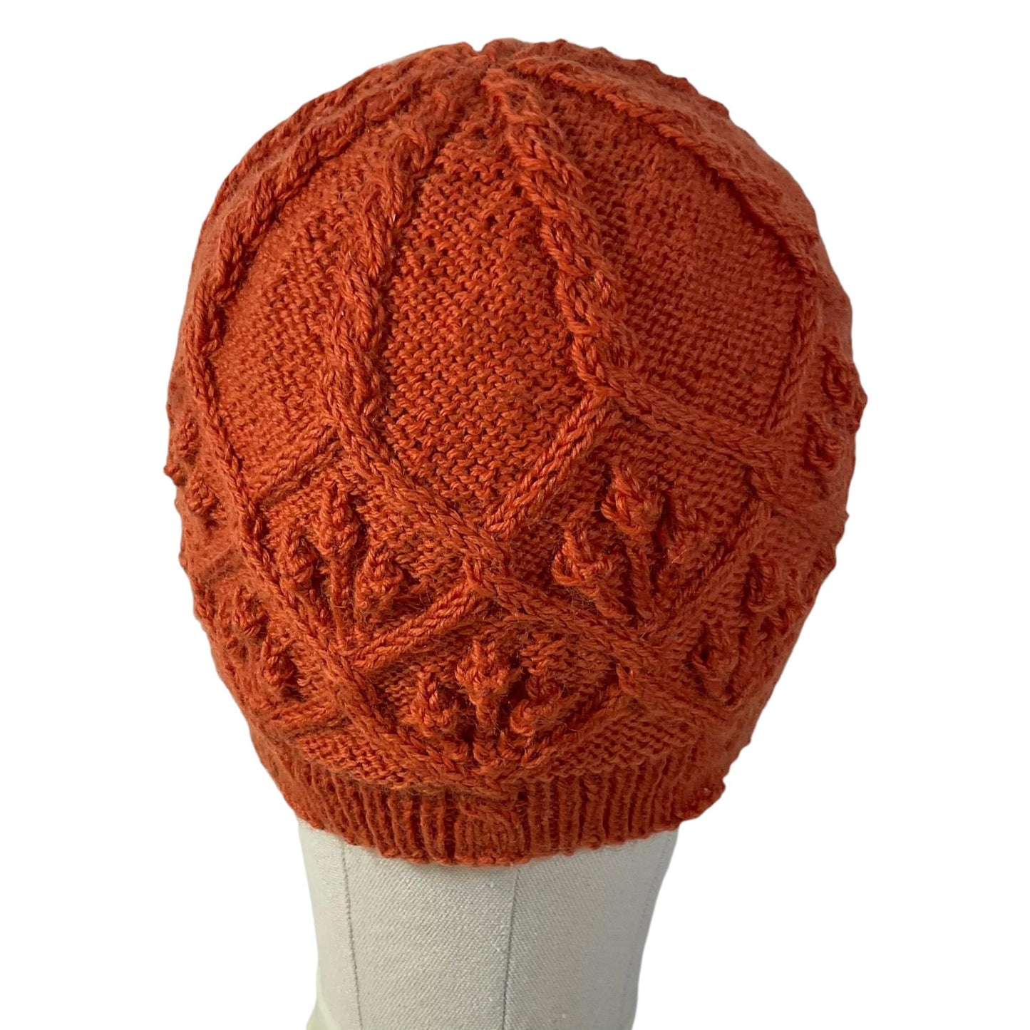 hand knitted cable and bobble hat in burnt orange